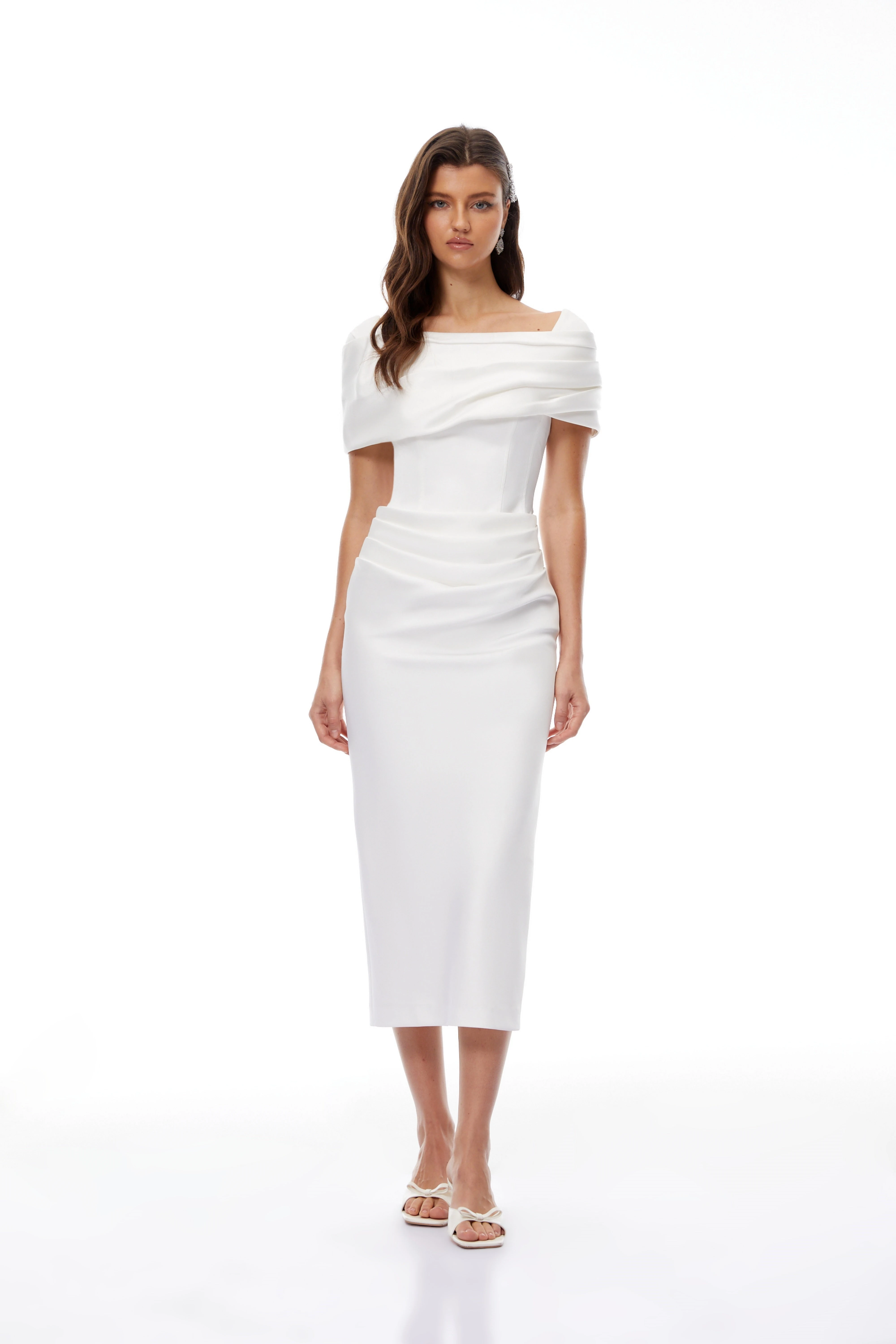 White off-the-shoulder gown with a draped bodice and cascading side ruffles