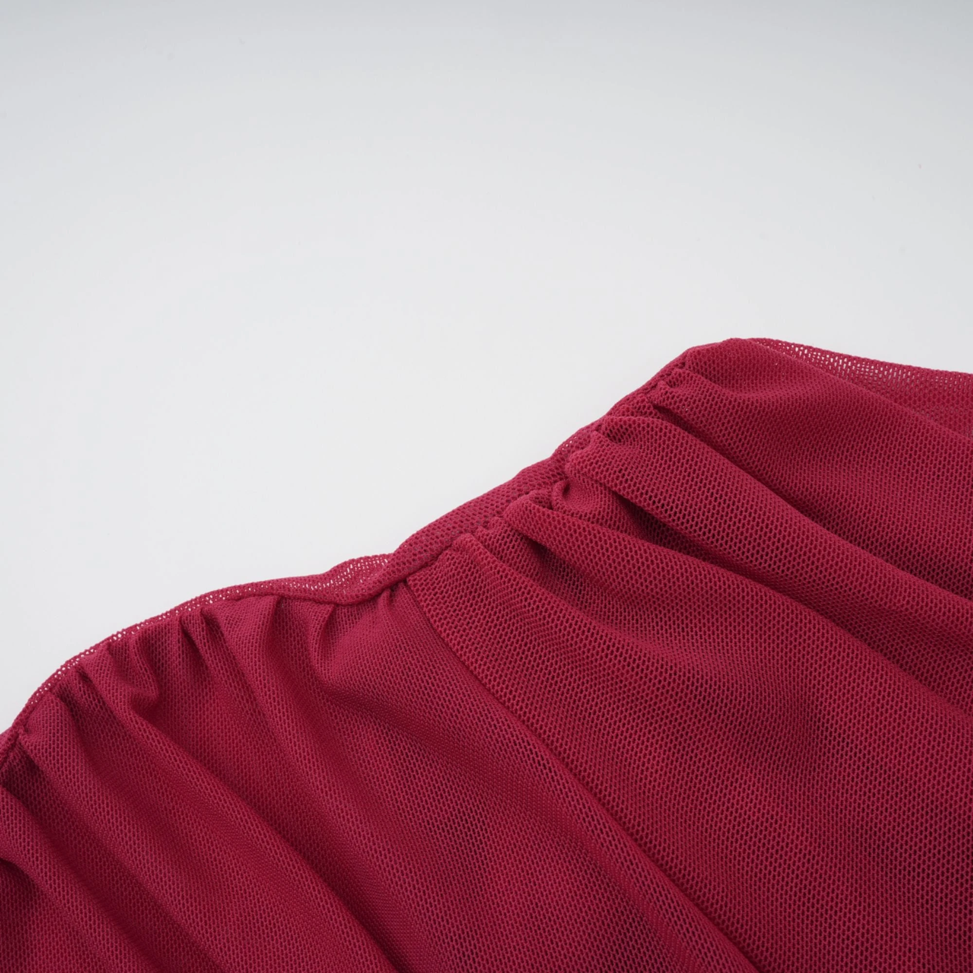 Burgundy ruched gown with a draped high neckline and sheer skirt
