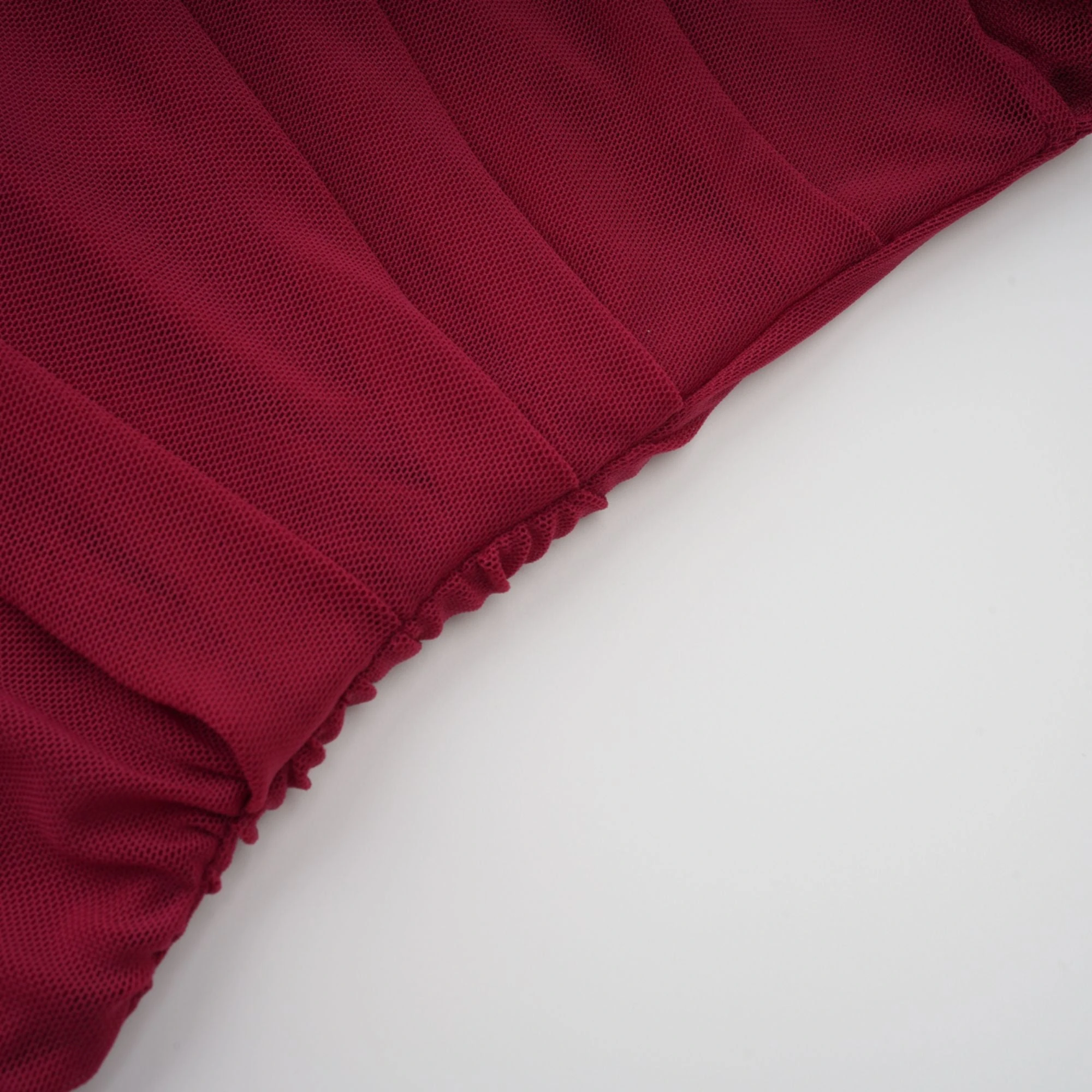 Burgundy ruched gown with a draped high neckline and sheer skirt