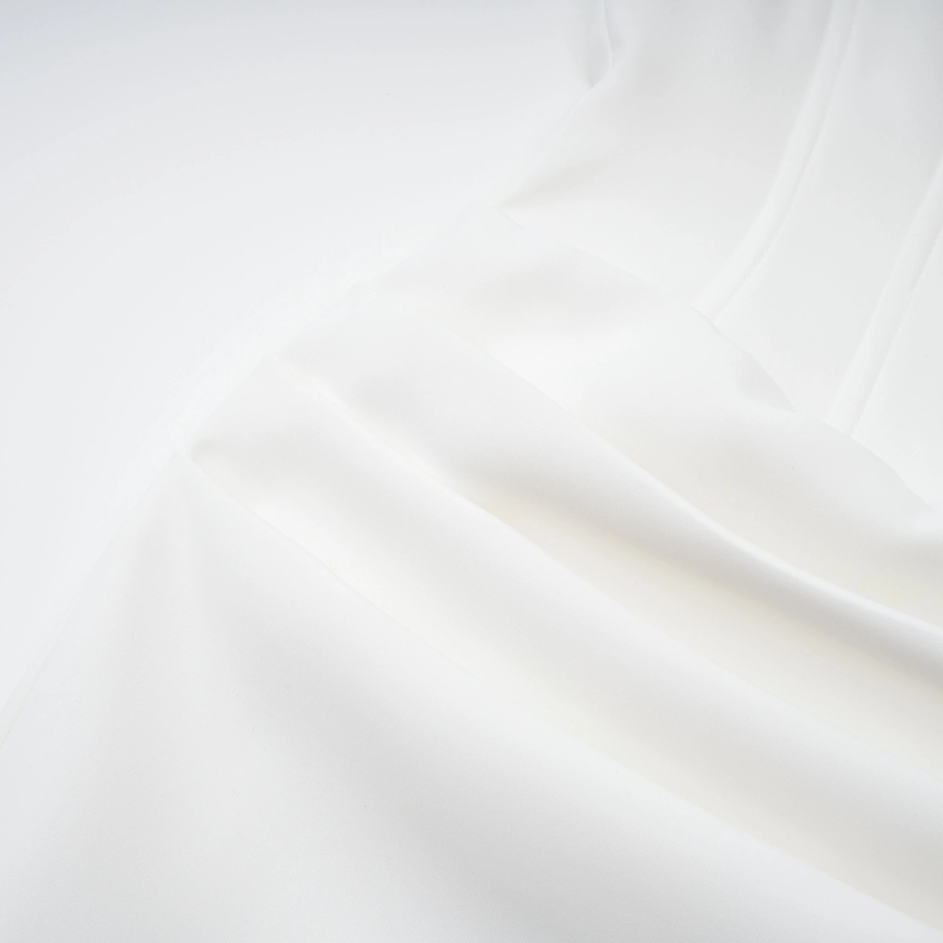 White off-the-shoulder gown with a draped bodice and cascading side ruffles