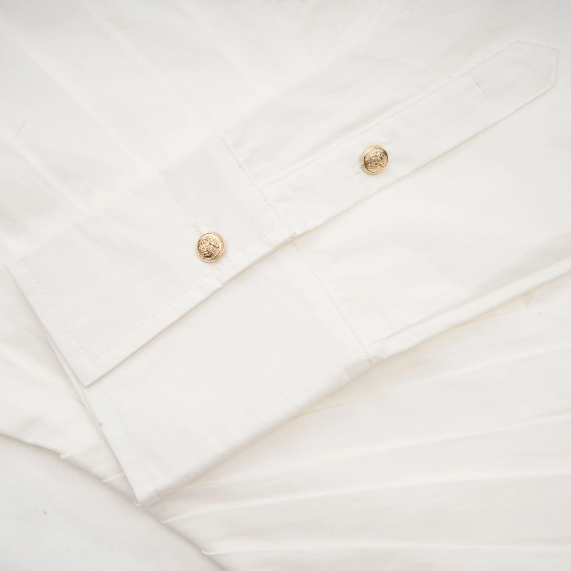 White long-sleeve corset shirt dress with a draped mini skirt