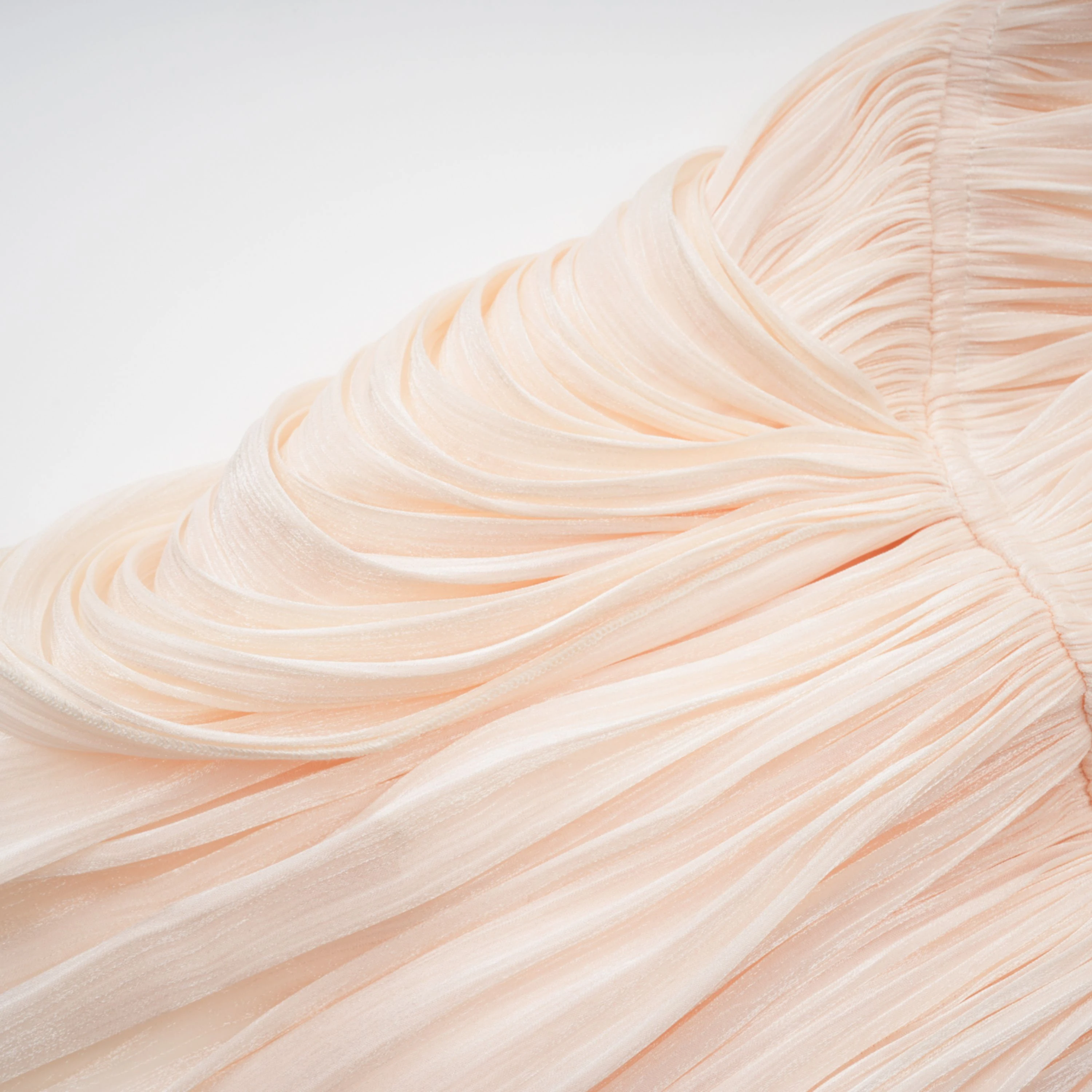 Cream plissé mini dress with a square neckline, structured puff sleeves, and a draped ruffled skirt