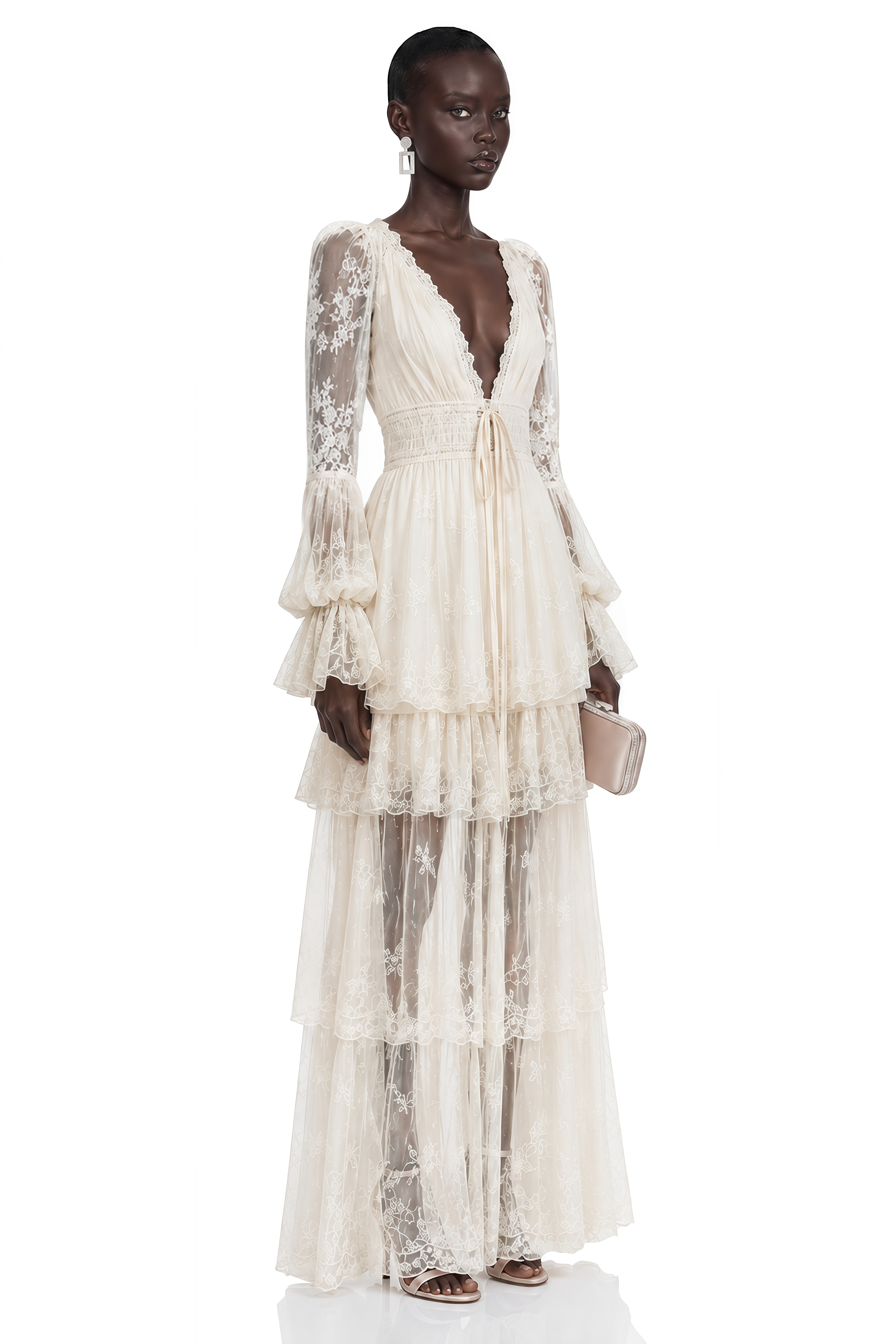 Off-white lace long-sleeved gown with deep V-neckline and tiered skirt.