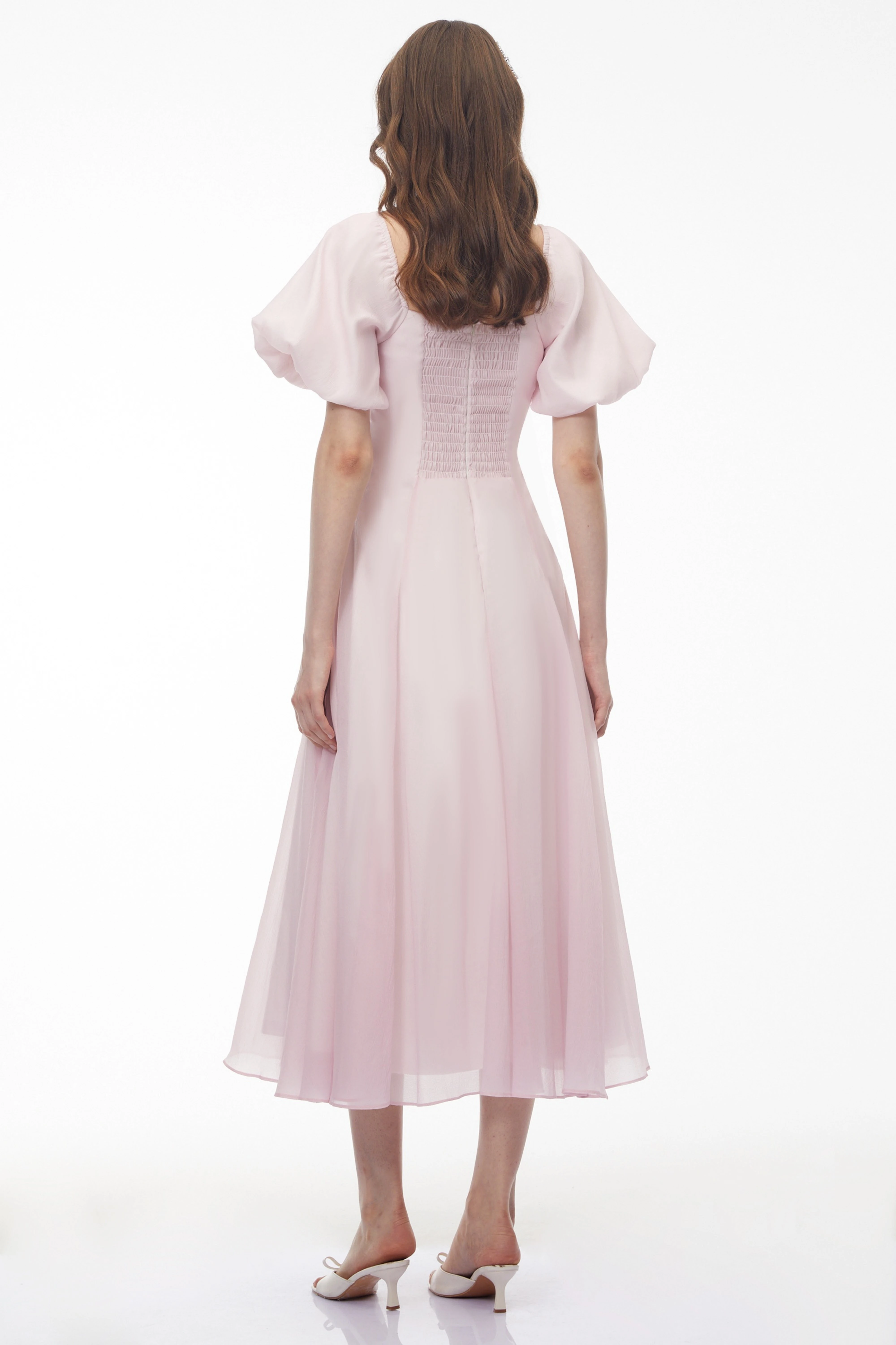 Light pink midi dress with puff sleeves, a ruffled sweetheart neckline, and a pleated skirt